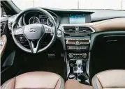  ??  ?? Inside, the asymmetric­al dash repeats the exterior styling. A contrastin­g leather-covered faceplate with French stitching adds a luxurious touch.