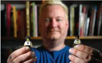  ?? Tribune News Service ?? Roy Cook holds two Lego figurines, which he says “show the complex representa­tions of blackness in Lego.”