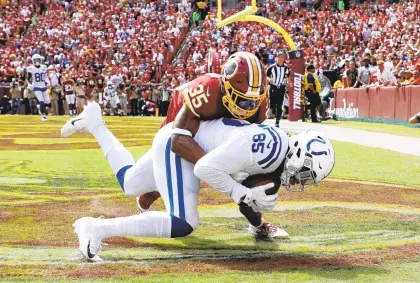  ?? ROB CARR/GETTY IMAGES ?? Colts tight end Eric Ebron catches a touchdown pass against Montae Nicholson last week in a game that dropped the Redskins to 1-1.