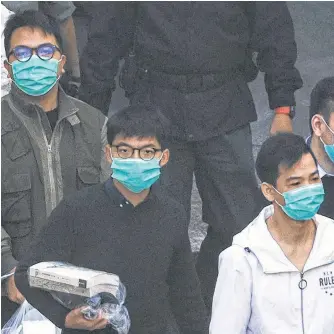  ?? REUTERS ?? Pro-democracy activists Ivan Lam, left, and Joshua Wong, middle, walk to a prison van in Hong Kong on Wednesday.