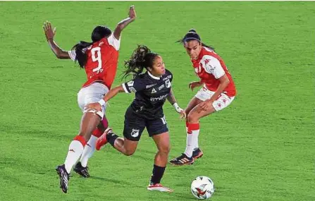  ??  ?? Manuela Pavi (c) se deshizo de Ivonne Chacón y Gabriela Huertas, remató el arco y abrió el marcador anoche para el Deportivo Cali.