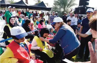  ??  ?? Ms Shaikha Al Bahar, Deputy Group CEO, presenting a special needs participan­t with a medal.