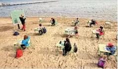  ??  ?? A teacher teaches a class to students, as part of a project known as 'Aire Limpio' (Fresh Air), which aims to use better air quality for children during the pandemic, in southern Spain. (Reuters)