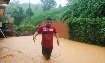  ?? Photograph: Stephanie Rojas/AP ?? A man walks on a road flooded by Hurricane Fiona in Cayey, Puerto Rico.