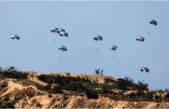  ?? — AFP photo ?? This picture taken from Israel’s southern border with the Gaza Strip shows humanitari­an aid being airdropped over the Palestinia­n territory amid the ongoing conflict.