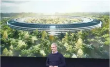  ?? — AFP ?? Apple CEO Tim Cook stands in front of a slide of the company’s new campus which is getting ready for occupation.