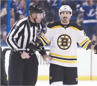  ?? - Associated Press: Chris O’Meara ?? Brad Marchand, des Bruins de Boston, est escorté jusqu’au banc des pénalités par le juge de lignes Michel Cormier.