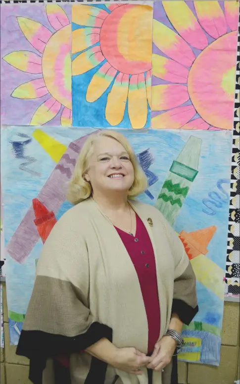  ?? TAMMY KEITH/RIVER VALLEY & OZARK EDITION ?? Becky Thornton, who is in her 43rd year as an art teacher in the Conway School District, stands in her Carl Stuart Middle School classroom in front of paintings of flowers, including the one she did, in the upper right-hand corner. Thornton received the Judges Recognitio­n Award from the Arkansas Arts Council in its 2018 Governor’s Arts Awards program and will be honored in March at a luncheon.