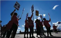  ?? ?? United Auto Workers members walk the picket line at the Ford Michigan Assembly Plant in Wayne, Mich., on Sept. 18. The long-battered American labor movement flexed its muscle in 2023, taking advantage of widespread worker shortages to demand — and get — better pay and benefits.