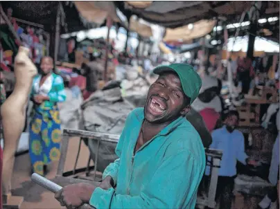  ?? AP PHOTO ?? A vendor at a local clothes market laughs as he pushes a trolley in Harare, Zimbabwe, Thursday. Zimbabwean­s prepare for their new president in waiting, Emmerson Mnangagwa’s swearing in on Friday after 37-years of rule by Robert Mugabe.
