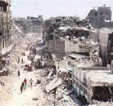  ?? — AFP ?? Palestinia­ns carry some salvaged belongings as they leave the Jabalia refugee camp in the northern Gaza Strip.