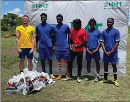  ?? ?? Young Warriors player Sebastein Summerfiel­d (left) yesterday donated a soccer kit to the Alois Bunjira Academy as an appreciati­on of the institutio­n’s contributi­on to local junior football developmen­t. Bunjira (in a red top) said the donation will help motivate the upcoming players.