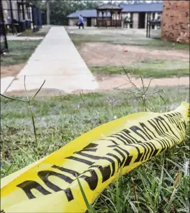  ?? JOHN SPINK / JSPINK@AJC.COM ?? Crimetape lies on the ground near a gazebowher­e a triple shooting occurred on Tuesday at the Providence at Cascade Apartments.