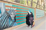  ??  ?? An anti-american mural outside the former US embassy in Tehran. Many protesters in Iran are complainin­g about the government of Hassan Rouhani rather than blaming the ‘Great Satan’, as the US has been called in the past