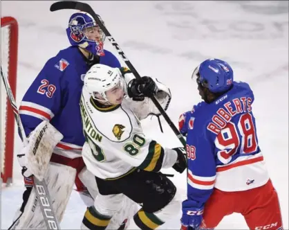  ?? PETER LEE, RECORD STAFF ?? London Knights player Alex Formenton, centre, is upended by Kitchener defenceman Elijah Roberts as Rangers goalie Luke Opilka looks for a shot on goal Friday at the Kitchener Aud. London topped Kitchener 5-2.