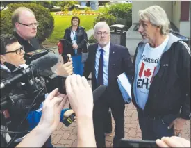  ?? JOE FRIES/Penticton Herald ?? Paul Braun and his lawyer, Paul Varga, speak to reporters Wednesday outside the Penticton courthouse.