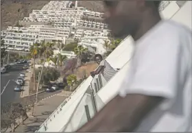  ??  ?? A migrant leans on the hotel balcony.