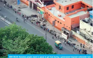  ?? — AFP ?? NEW DELHI: Homeless people stand in queue to get food during a government-imposed nationwide lockdown as a preventive measure against the COVID-19 coronaviru­s in New Delhi.