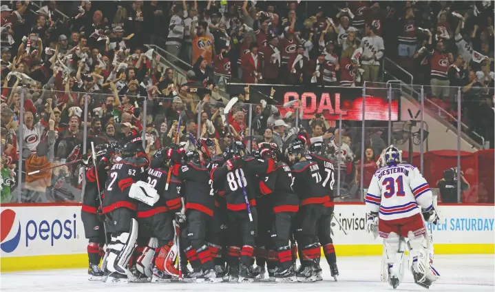  ?? GETTY IMAGES ?? Ian Cole scores at 3:12 of OT against Igor Shesterkin to give the Carolina Hurricanes a 2-1 win over the New York Rangers in Game 1 of their series on Wednesday.