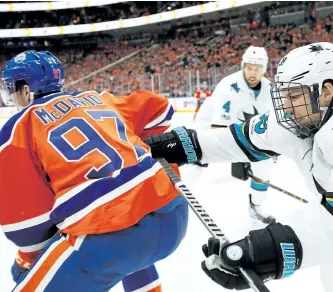  ?? CODIE MCLACHLAN/GETTY IMAGES ?? San Jose’s Logan Couture, right, crosscheck­s Edmonton’s Connor McDavid during Game 2 of their first-round playoff series. Couture has been tasked with trying to shut down the Oilers star.