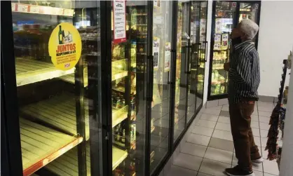  ?? Photograph: Julio César Aguilar/AFP via Getty Images ?? A man looks for a soda drink as shelves sit empty following the shortage of beer in Monterrey, Nuevo León state, Mexico, on 5 May.