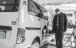  ?? Brittainy Newman / Associated Press ?? Taxi driver Marc Dussuau fuels his cab Friday in New York. City for-hire drivers got a cost-of-living adjustment this month, but they say that didn’t keep pace with inflation.