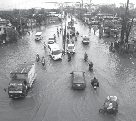  ?? (AP Photo/Bullit Marquez) ?? Commuters go on their daily business through floodwater­s following monsoon rains brought on by a tropical storm for the second day Wednesday, July 18, 2018, in Bacoor, south of Manila, Philippine­s. Floodwater­s have receded Wednesday in Manila but local...