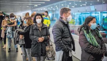  ?? Manu Fernandez The Associated Press ?? People line up Wednesday at a mass vaccinatio­n site in Madrid. Spain resumed the use of the Astrazenec­a vaccine Wednesday.