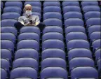  ?? BEN MCKEOWN — AP ?? Fan Mike Lemcke sits in an empty Greensboro Coliseum after the games were canceled at the ACC Tournament on Thursday. Live sporting events might not return to the U.S. until May.