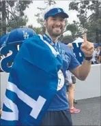  ?? Hailey Branson-Potts Los Angeles Times ?? LEO CRUZ of Fontana is draped in blue after running Sunday’s Dodgers 10K race. Cruz calls the postseason “nervous time.”