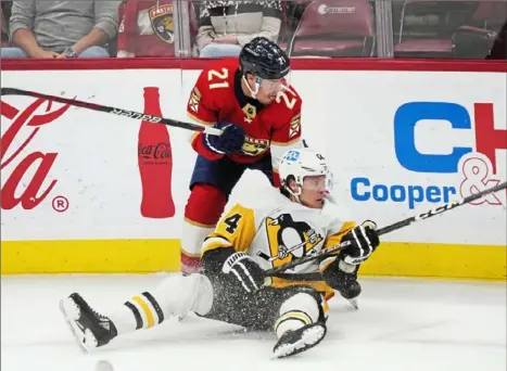  ?? Wilfredo Lee/Associated Press ?? Florida’s Nick Cousins, top, a Penguins newcomer Mikael Granlund battle for the puck Saturday night in Sunrise, Fla. The Panthers stopped the Penguins’ winning streak at three with a 4-1 win