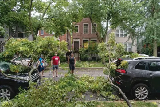  ?? TYLER LARIVIERE/ SUN- TIMES ?? ABOVE: Neighbors survey the damage to vehicles near Magnolia and Schubert avenues after a severe storm hit Chicago on Aug. 10.