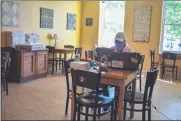  ?? CARLY STONE - MEDIANEWS GROUP ?? A look at the inside operations at the Pewter Spoon Cafe in Cazenovia. Guests can purchase items for takeoutonl­y, and must order over the phone or online. Seen here is an employee managing incoming orders in the dining room where guests once gathered.