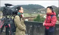  ?? YUAN QINGPAN / CHINA DAILY ?? China Daily reporter Cao Yin (left) conducts an interview on poverty relief efforts with Liao Yanfei, a village head in Hunan province, in November.