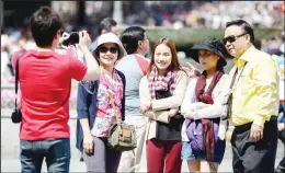  ??  ?? This file photo taken on April 19, 2014 shows a group of Asian tourists taking a picture at
the Puerta del Sol Square in Madrid. (AFP)