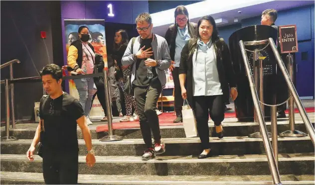  ?? Kamal Kassim / Gulf Today ?? ↑
Filipinos emerge from a cinema in Al Ghurair Centre in Dubai after watching the film ‘Gomburza’ on Wednesday evening.