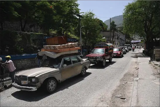  ?? RICHARD PIERRIN — AFP VIA GETTY IMAGES/TNS ?? Residents evacuate the Carrefour Feuilles commune in Port-au-Prince, Haiti on Aug. 15, as gang violence continues to plague the Haitian capital.