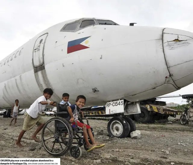  ?? JOHN JEROME GANZON | DREAMSTIME.COM ?? CHILDREN play near a wrecked airplane abandoned in a dumpsite in Parañaque City.