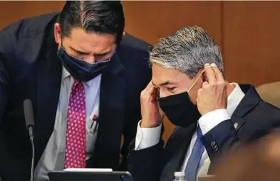  ?? Photos by Bob Owen / Staff photograph­er ?? Mayor Ron Nirenberg slips on his mask as he listens to City Manager Erik Walsh during the City Council meeting. In the last two days, Bexar County has seen a spike in the number of new cases — 180 on Tuesday and 135 on Wednesday.