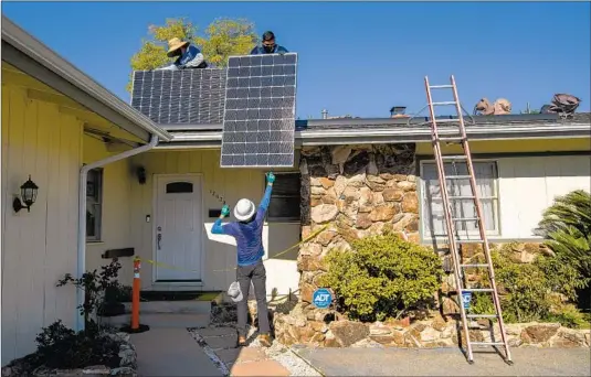  ?? ROOFTOP Mel Melcon Los Angeles Times ?? solar installers are making severe layoffs a year after the governor’s PUC picks gutted “net metering.” Above, panels go on a Granada Hills home in 2020.