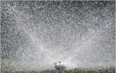  ?? AP PHOTO/RICH PEDRONCELL­I ?? Water flies from a sprinkler watering a lawn, in Sacramento, Calif., on Tuesday.