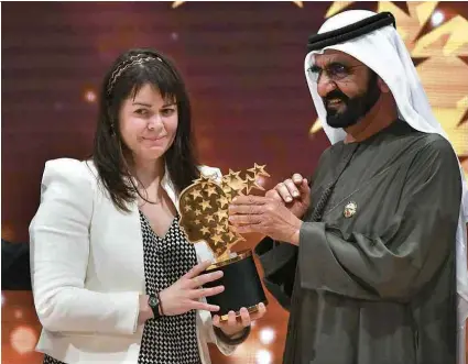  ??  ?? A canadense Maggie MacDonnell recebe prêmio do emir de Dubai Sheikh Mohammed Bin Rashid Al Maktoum