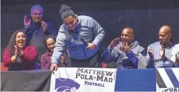  ?? TOM TINGLE/THE REPUBLIC ?? Matthew Pola-Mao (center, with his parents Carrie, third from left, and Tracey Pola-Mao) announces that he will play football for Kansas State during a signing event at the Chandler Center for the Arts on Wednesday.