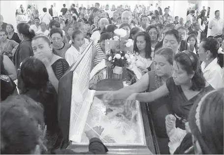  ?? Marco Ugarte Associated Press ?? MOURNERS pay last respects to the Rev. Jose Alfredo Suarez de la Cruz, gunned down last month in the state of Veracruz. More than a dozen priests have been killed across Mexico in the last four years. Joining the grim list, a judge was killed this week...