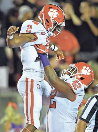  ?? JAMIE RHODES, USA TODAY SPORTS ?? While giving Clemson a big lift in his first three college starts, quarterbac­k Kelly Bryant got a lift from defensive lineman Christian Wilkins after a TD on Saturday.