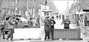  ??  ?? Afghan security personnel stand guard near the site of a suicide bombing at Shash Darak in Kabul. — AFP photo