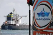  ??  ?? A cargo ship sails through the town of Ismailia, Egypt, Tuesday, as traffic resumed through the Suez canal after it was blocked by a massive ship for nearly a week.