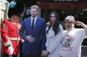  ?? — AP ?? A soldier looks at a royal fan with a cardboard cutout of Britain’s Prince Harry and Meghan Markle in Windsor on Tuesday.