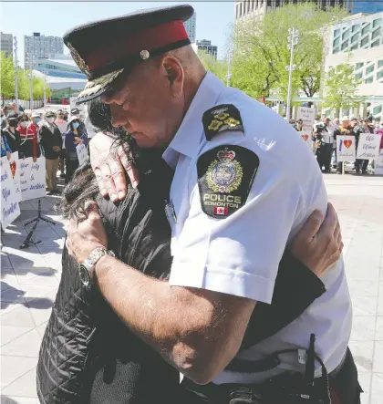  ?? DAVID BLOOM ?? Edmonton Police Chief Dale Mcfee hugs Holly Mah, chair of the Chinatown and Area Business Associatio­n, during a rally on Saturday.