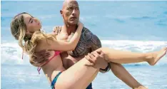  ?? Foto: Frank Masi/Paramount Pictures/dpa ?? Rettungssc­hwimmer Mitch Buchannon trägt im Film „Baywatch“Carmen aus dem Wasser. Der Film läuft seit dem 1. Juni.